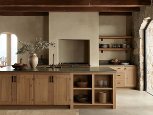 Artisan Studio kitchen with oak cabinetry, matte stone counters, plaster walls and handcrafted décor in a calm, natural material palette.