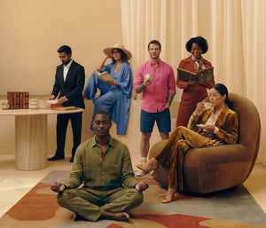 Group of people in a modern living room setting, with one person meditating.