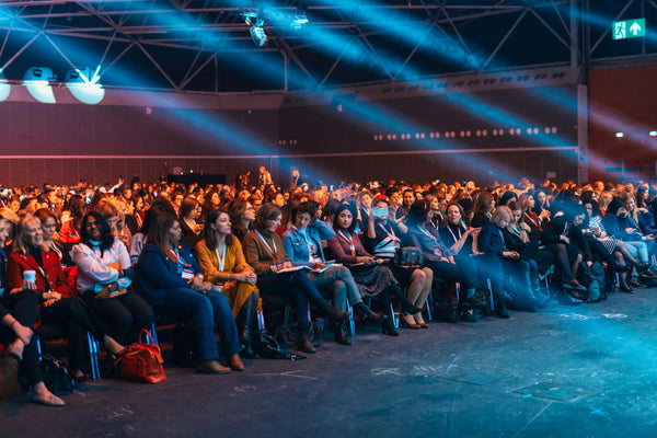Audience in a conference hall with blue lighting