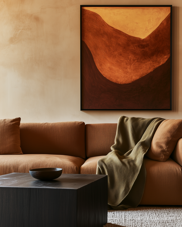 Earth-toned living room with rust sofa, abstract wall art, textured throw blanket, dark coffee table, and warm interior styling.