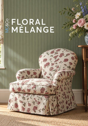 A floral slipcovered armchair in a styled room with sage green beadboard wall, a side table with flowers, and text reading 'MC&Co FLORAL MÉLANGE' in the upper left.