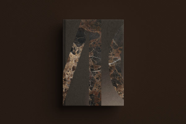 A hardcover book or journal with a dark marble-patterned cover, displayed against a solid dark brown background.